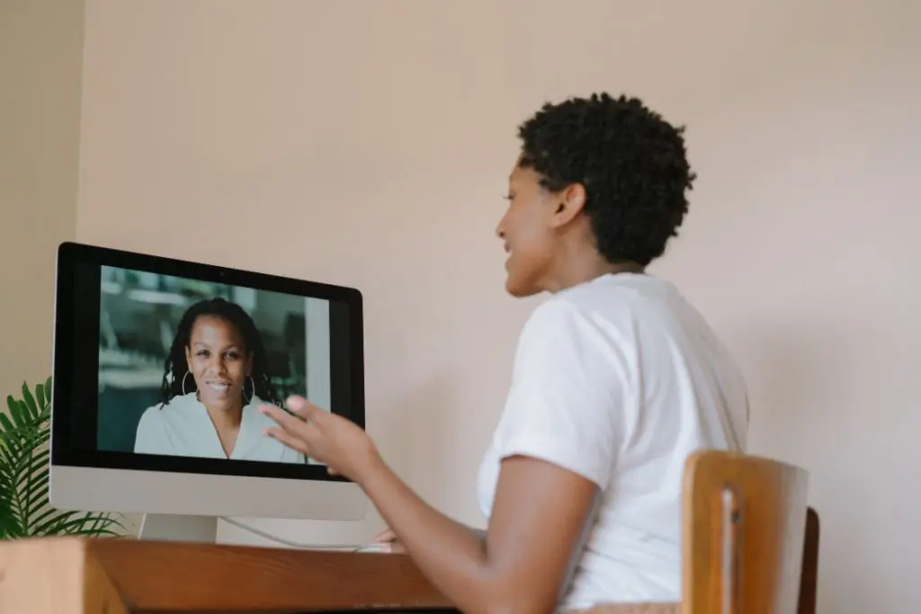 Two women talking to each other over the computer.