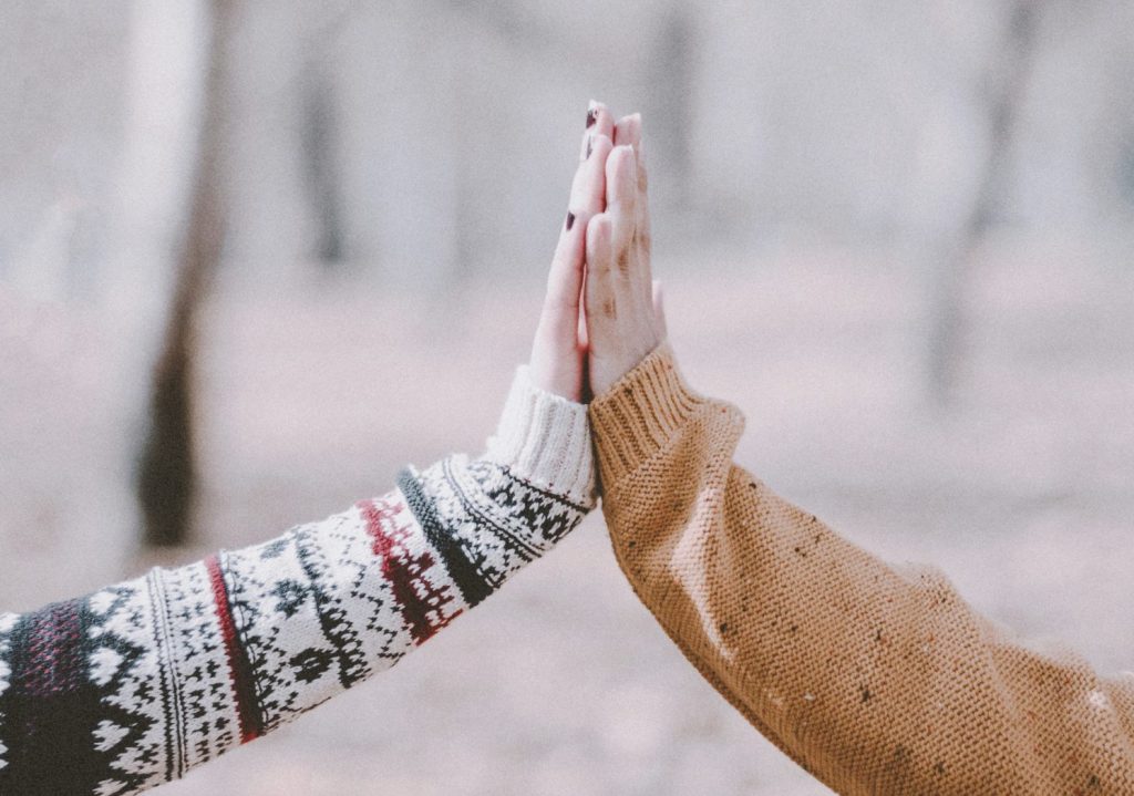 A lady laying down on a surface looking troubled with her wrist on her forehead