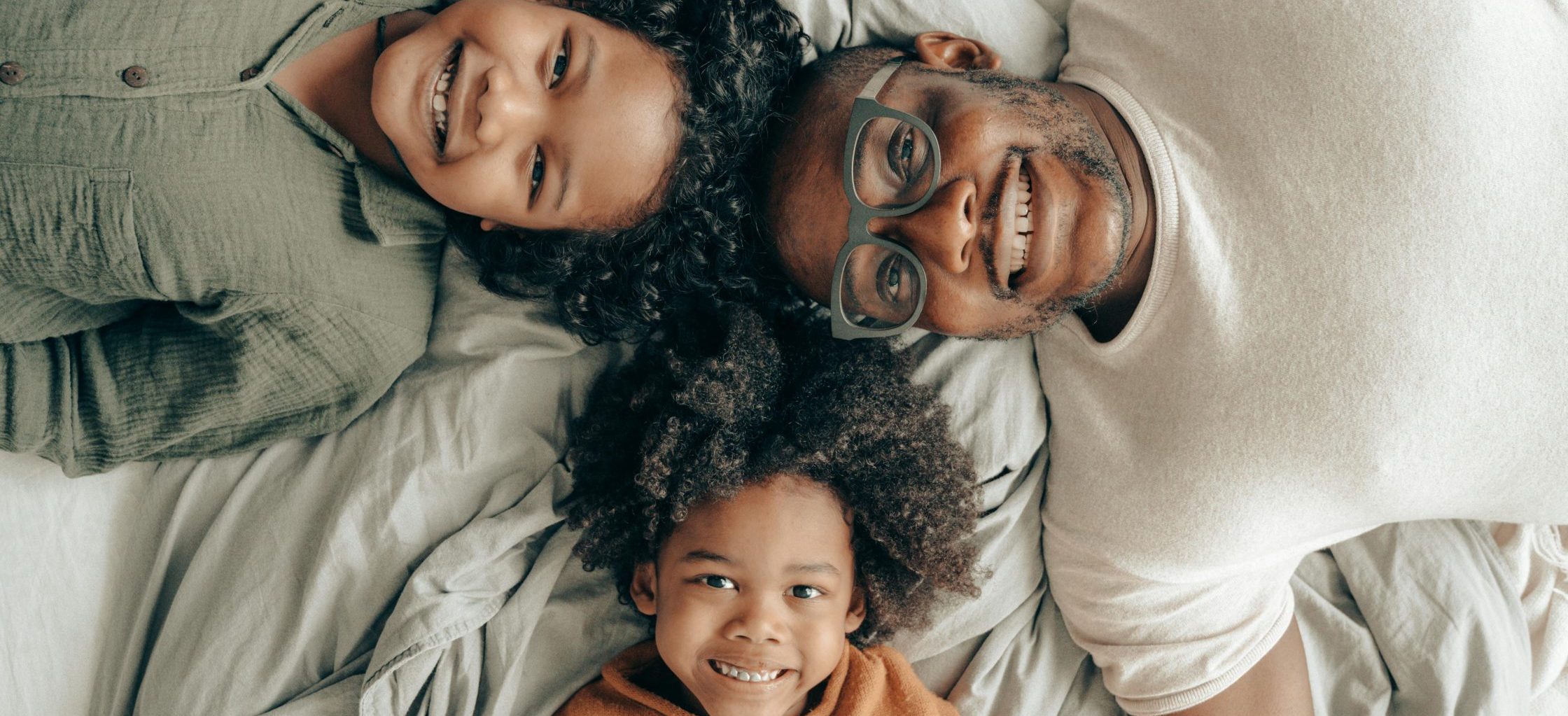 happy father and 2 children laying down on backs